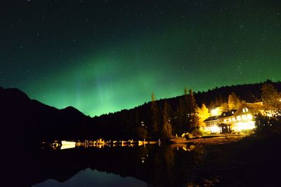 Scenic view of lake by mountains against star field