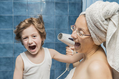 Mother screaming while drying son hair in bathroom