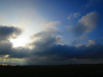 Scenic view of silhouette field against sky during sunset