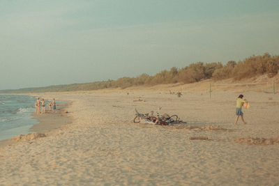 People on beach against clear sky