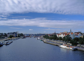 Boats moored at harbor against sky