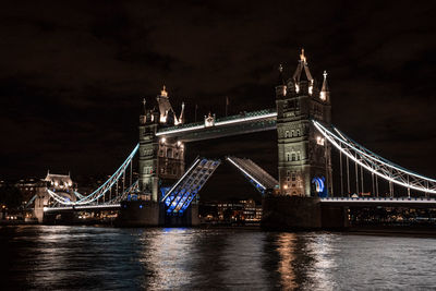 London tower bridge lifting up at night.