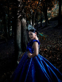 Side view portrait of young woman standing at forest