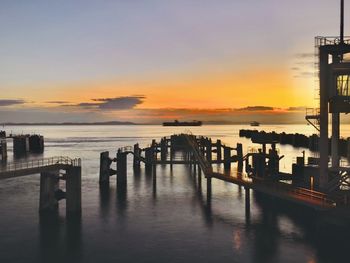 Pier on sea against sky during sunset