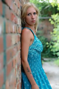 Portrait of beautiful woman standing against wall