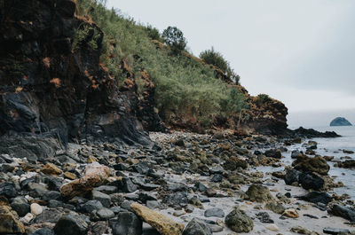 Rocks by sea against sky