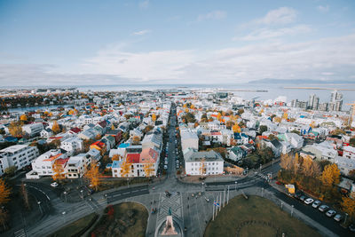 High angle view of townscape by sea against sky