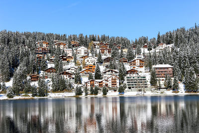 Scenic view of lake by buildings against clear sky