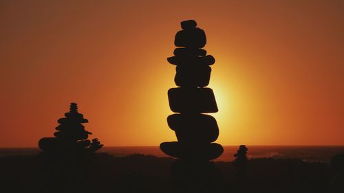 Silhouette of stack against sunset sky