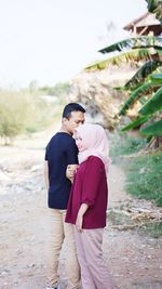 Side view of man and woman standing outdoors