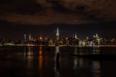 Illuminated buildings in city against sky at night