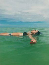 Man swimming in sea against sky