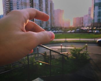 Close-up of person hand on railing in city