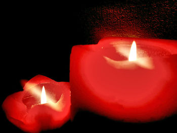 Close-up of lit candle in darkroom