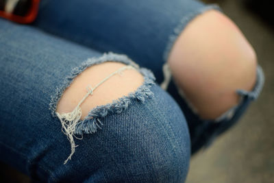 Midsection of woman wearing torn jeans outdoors