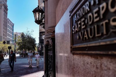 People walking on street against buildings in city