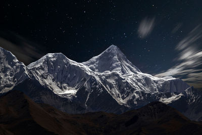 Scenic view of snowcapped mountains against sky at night