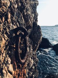 Close-up of rock on sea shore against sky