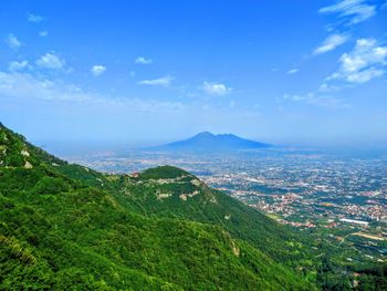 Scenic view of landscape and mountains against blue sky