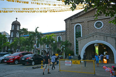 People on street against buildings in city