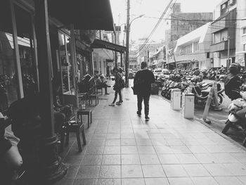 People walking on footpath in city