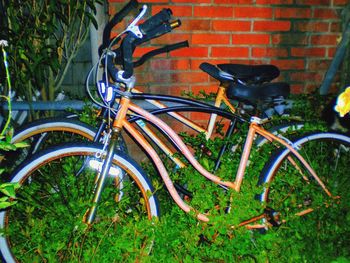 Close-up of bicycle parked against brick wall