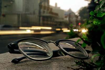 Close-up of eyeglasses on table by street in city