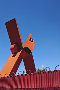 Low angle view of traditional windmill against clear blue sky