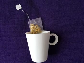 Directly above shot of tea bag and mug on textile