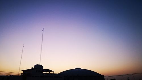 Low angle view of silhouette house against sky at sunset