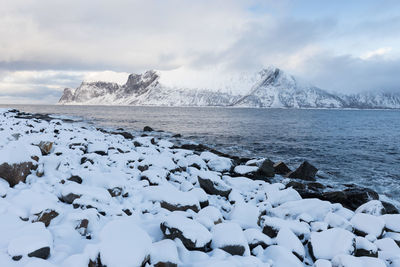 Scenic view of snowcapped mountains by sea against sky