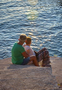 Rear view of couple sitting on sea shore