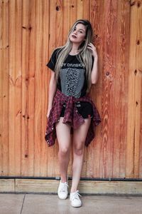 Portrait of young woman standing against wall