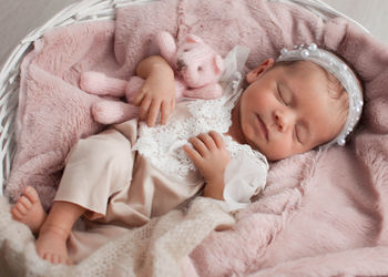 High angle view of cute baby sleeping on bed at home