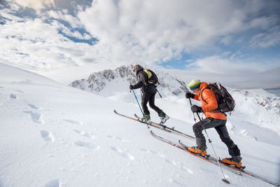 Full length of people on snowcapped mountain against sky