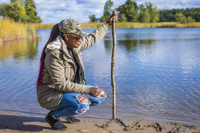 African woman searches for tracks in nature during a beautiful autumn day by the sea
