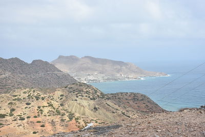 Scenic view of sea and mountains against sky