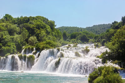 Scenic view of waterfall against sky