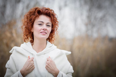 Close up portrait of attractive woman in trendy white coat