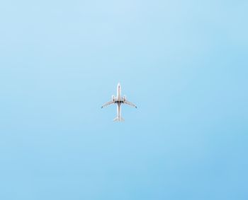Low angle view of airplane flying against clear sky