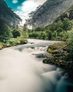 Scenic view of waterfall against sky