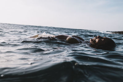 Close up dramatic view of a woman in a bikini floating