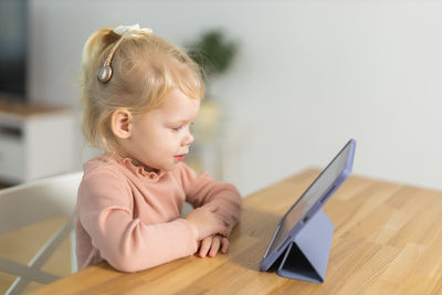 Close-up of cute baby boy sitting on table