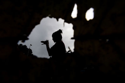 Silhouette of woman against sky at sunset