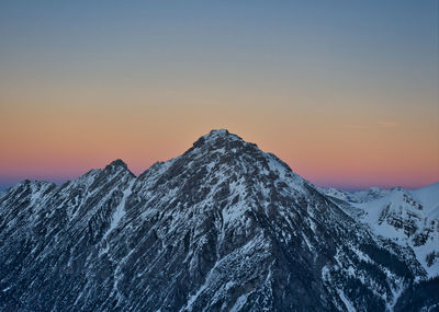 Scenic view of snowcapped mountains against sky during sunset