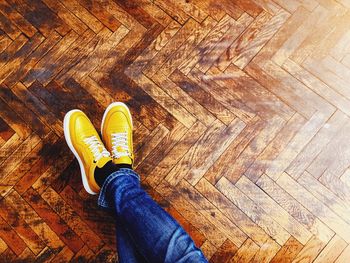 Low section of person standing on hardwood floor