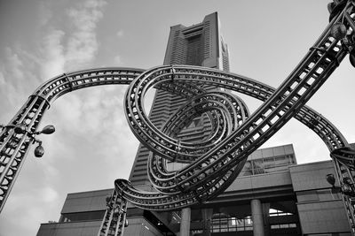 Low angle view of ferris wheel against buildings