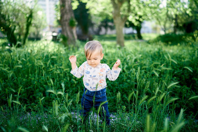 Full length of cute baby girl in grass