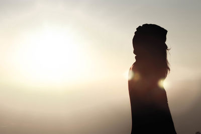 Silhouette woman standing against sky during sunset