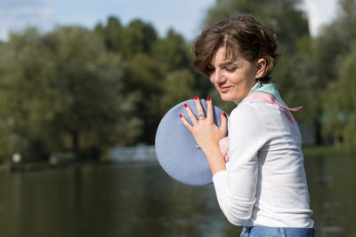 Side view of young woman holding umbrella
